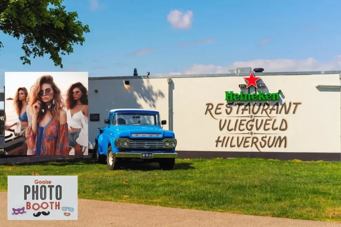 Restaurant Vliegveld Hilversum met een blauwe pick-up op het gras en de Gooise Photo Booth
